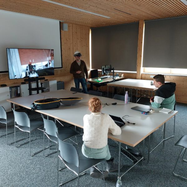 20230215_135721 Dipl. Ing. Christoph Matschi, M. Sc., zeigt Liah und Alessandro den Nut- zen einer AR-Brille für Gebäudebau, -planung und -technik.