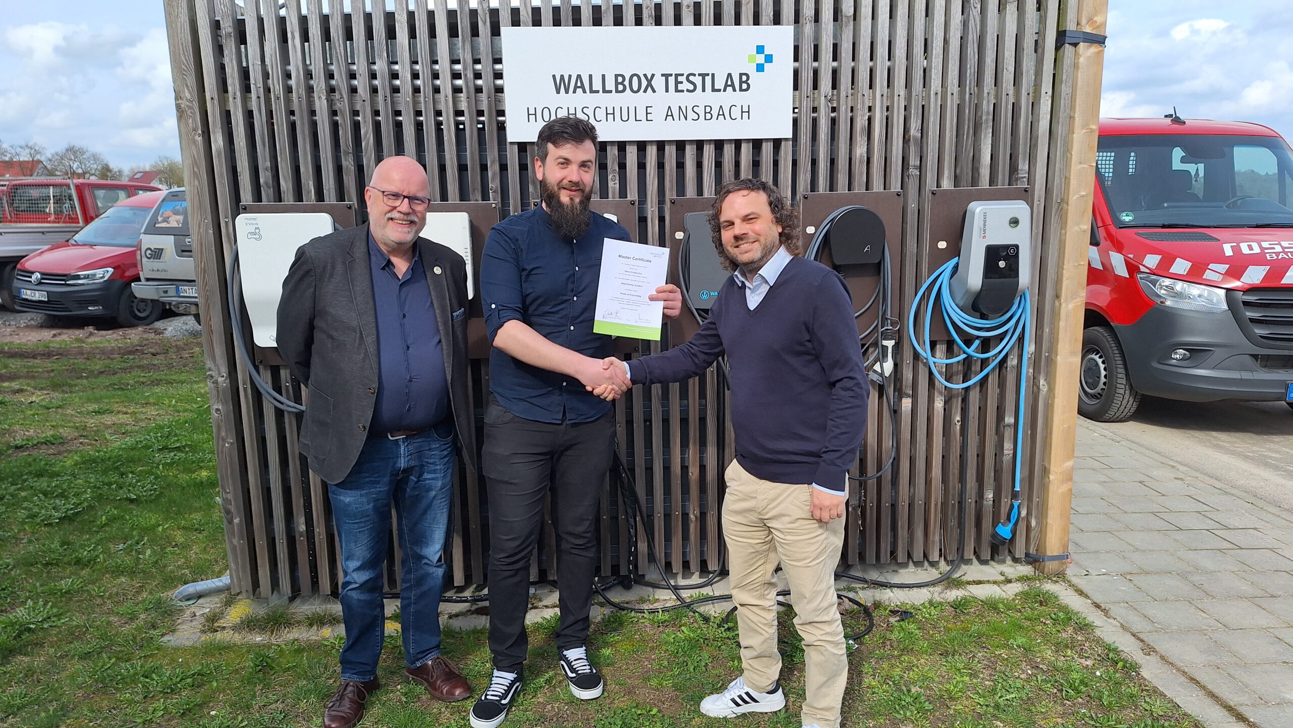 Studiengangleiter Prof. Dr.-Ing. Johannes Jungwirth (r.) überreicht zusammen mit dem Leiter des Studierendenservice Ralph-Peter Kappestein (l.) dem ersten Absolventen in Smart Energy Systems Cristian Silviu Eva (m.) sein Abschlusszeugnis.